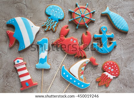 Homemade homemade gingerbread cookies in the shape of steering wheel, lighthouse, ship, fish and anchor on a wooden background