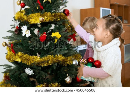 Happy children decorate fir for Christmas and New Year Eve