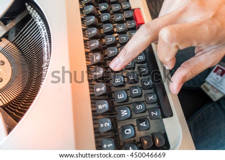 Hands writing on old typewriter

