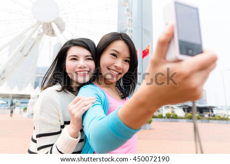 Woman taking selfie by camera in Hong Kong