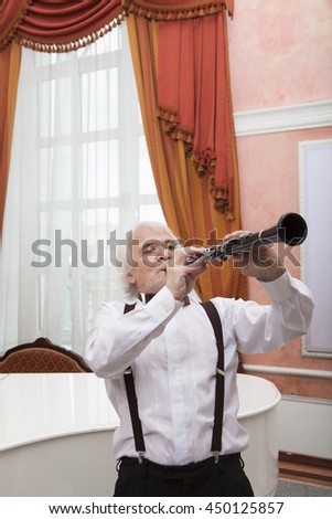 Vigorous charming aging musician plays the clarinet