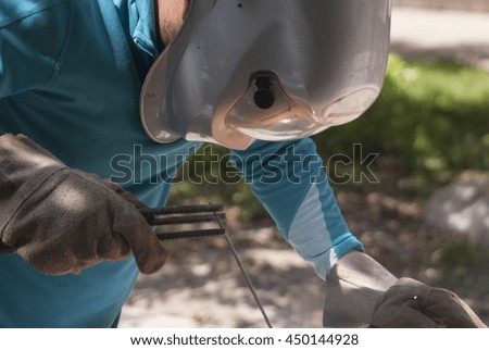 Welder worker welding metal. Bright electric arc and sparks