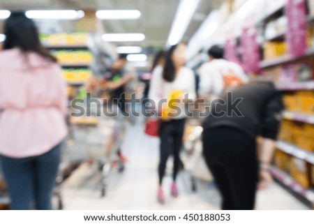 people shopping in supermarket grocery aisle blurred background