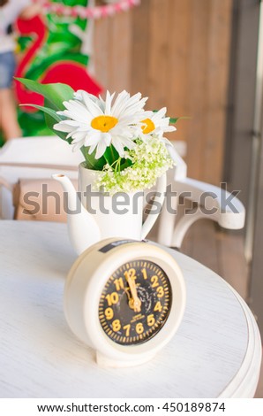 ld clock on a table with flowers