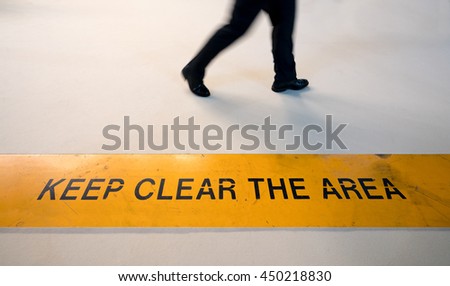 Man walking in prohibited area with motion blur, coronavirus lockdown social distancing or breaking rule concept, keep clear sign on the floor with copy space