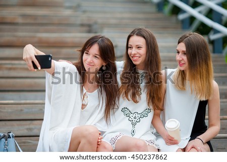 Lifestyle selfie portrait of young positive girls having fun and making selfie. Concept of friendship and fun with new trends and technology. Best friends saving the moment with modern smartphone