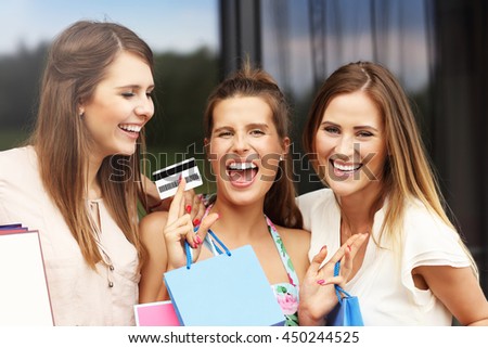 Picture presenting group of girlfriends shopping in the city with credit card