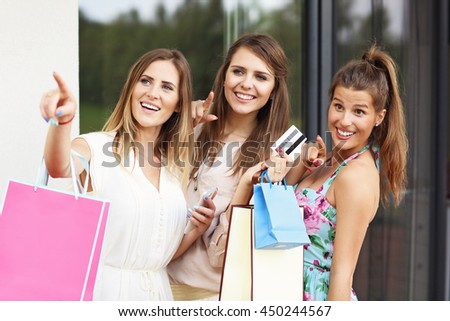 Picture presenting group of girlfriends shopping in the city with credit card and smartphone