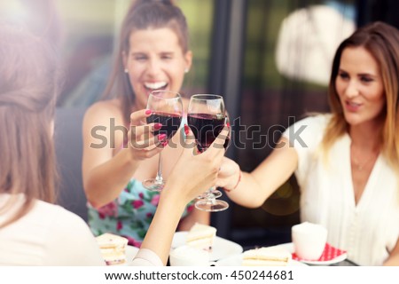 Picture presenting happy group of friends with red wine