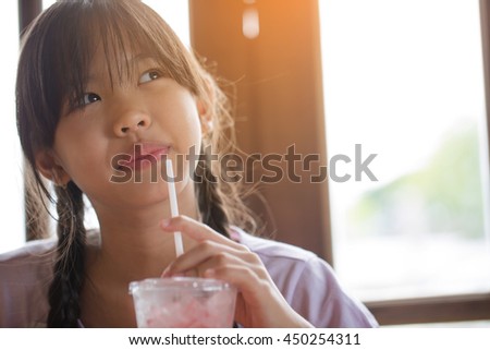 Happy Asian girl drinking ice strawberry smoothie in cafe