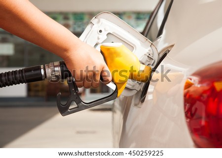 Car refueling on petrol station. To fill the machine with fuel.  Fuel pump at station. Man pumping gasoline fuel in car at gas station. Royalty-Free Stock Photo #450259225