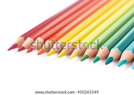 Multiple colorful color pencils composition arranged in a line to form a rainbow gradient, composition isolated over the white background, close-up crop fragment