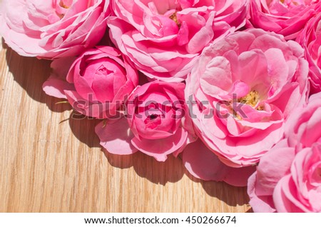 Beautiful background of pink roses on wooden background. roses background - fresh pink rose flowers close up. Background for cards, place for text