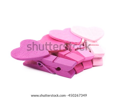 Pile of multiple tiny heart shaped colored wooden peg pins, composition isolated over the white background
