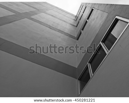 Abstract modern architecture. Perspective of tall building with dark windows and walls.