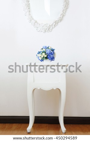 Vintage lamp and artificial bouquet on white small desk, Home decoration concept