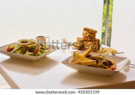 Square shaped clubhouse sandwich and vegetable salad
