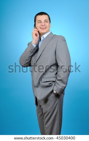 Handsome businessman talking with cell phone  on blue background