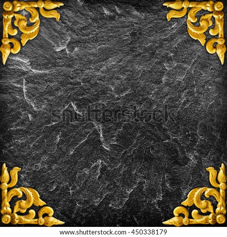 Pattern of gold Stucco flower on a black stone.