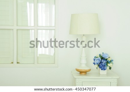 Vintage lamp and artificial bouquet on white small desk, Home decoration concept