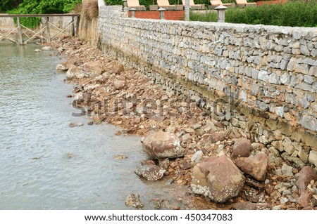 Rough rock beach with stone wall 
