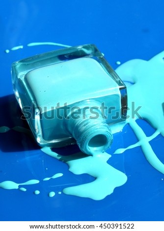 Nail polish enamel liquid bottle on blue background