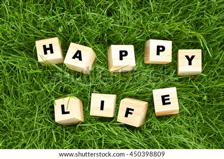 Words HAPPY LIFE on green grass