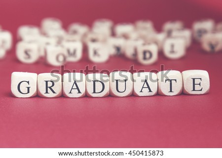 Graduate word written on wood cube with red background