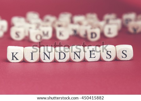 Kindness word written on wood cube with red background