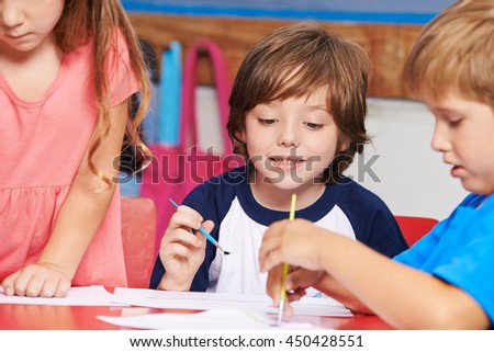 Children painting images with water color in art class in elementary school