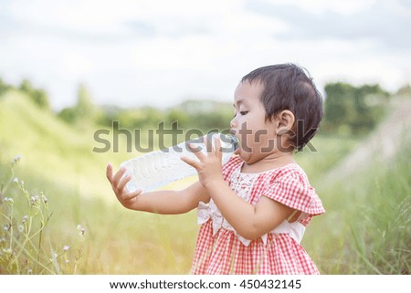 Lovely little girl drinking water
