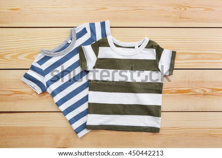 New baby clothes on wooden background