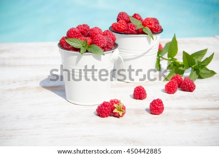 Sweet raspberries in bowl on wooden table. Close up, top view