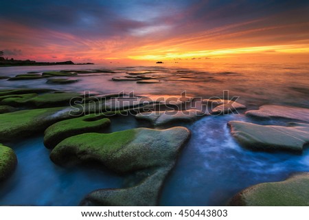 sunset view of green moss covered rocks boulders  at Kudat Sabah Malaysia.  Image contain soft focus and blur.
