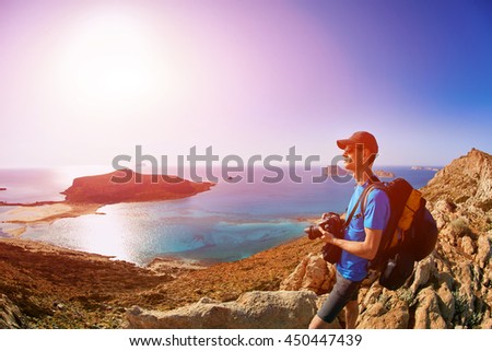 panoramic view on Balos beach, Crete, Greece. Man, traveller and photographer stands on the cliff and taking photo