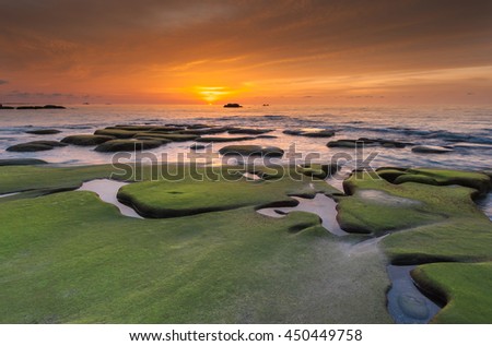 View of rocks covered by green moss at Kudat Sabah Malaysia. Image taken during sunset. Image contain soft focus and blur.