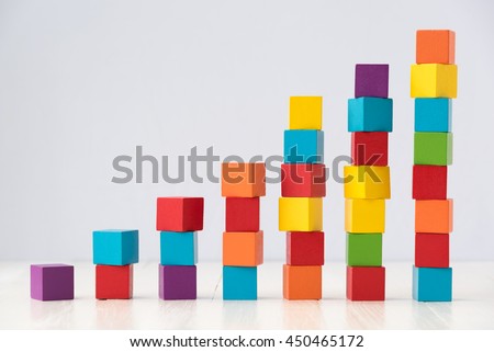 growning stack of colorful wood cube building blocks on white wood floor Royalty-Free Stock Photo #450465172
