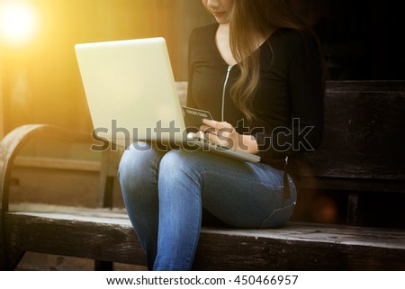 Young woman using laptop for shopping online hot deal product in special price and using credit card quickly pay for product online in holiday happy time, vintage picture with sunlight effect image.
