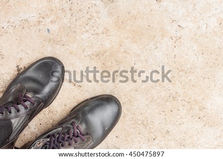 old combat boots on the cement floor, top view, with space for text