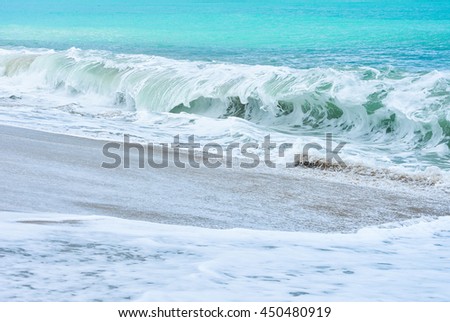 An ocean shorebreak in front view. Big beautiful green blue wave splashing with backwave and ready to break out. White foam sliding over sand.
powerful ocean waves breaking natural background, Phuket