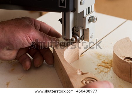 Carpenter tools on wooden table with sawdust. Band-saw to cut an intricate shape in a piece of wood.Carpenter workplace.