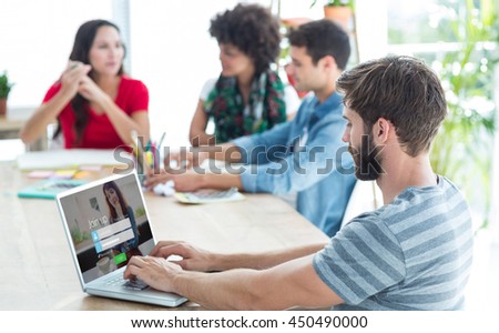 Casual businessman typing on his laptop against log-in screen with redheaded woman