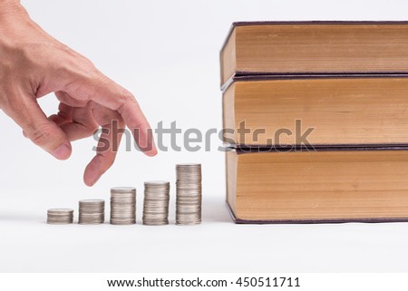 A man hand running up on coins to the books, invest in education of diploma and university student loan for study and money savings concept.