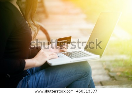 Young asian woman paying online product by credit card for shopping at home in holiday time, vintage picture style with sunlight effect photography.
