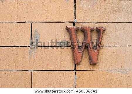 Single wooden toilet sign on brick wall
