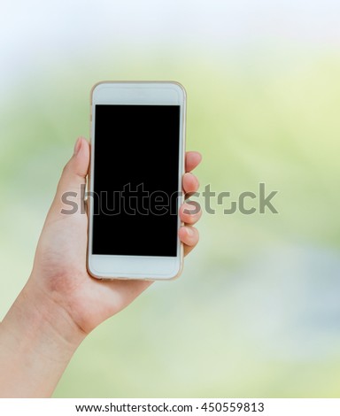 isolate hand using mobile phone on green bokeh of nature background with clipping path : Technology, people and object concept