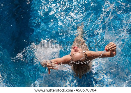 girl in a white bathing suit in the pool splash water