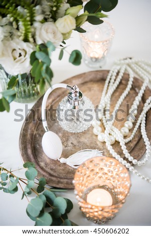 white wedding decor, perfume, pearl beads and bouquet of flowers