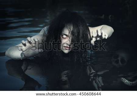 Terrible dead ghost woman in the water outdoor Royalty-Free Stock Photo #450608644