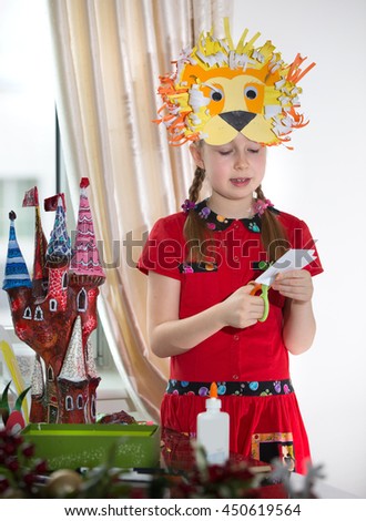 Little girl demonstrating her art craft works, Paper masher fairy castle and Lion mask she made. Educational and creative concept.